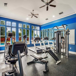 A fresh, bright fitness center with treadmills, eliptical, bicycle and cybex machine alternate view