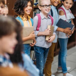 school kids smiling and holding books